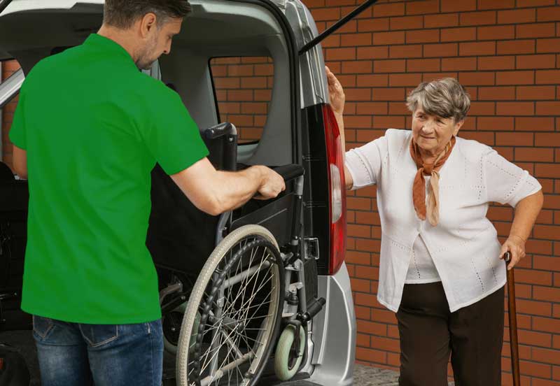 caregiver-holding-wheelchair-in-the-car-for-disabled-elderly-woman-with-walking-stick